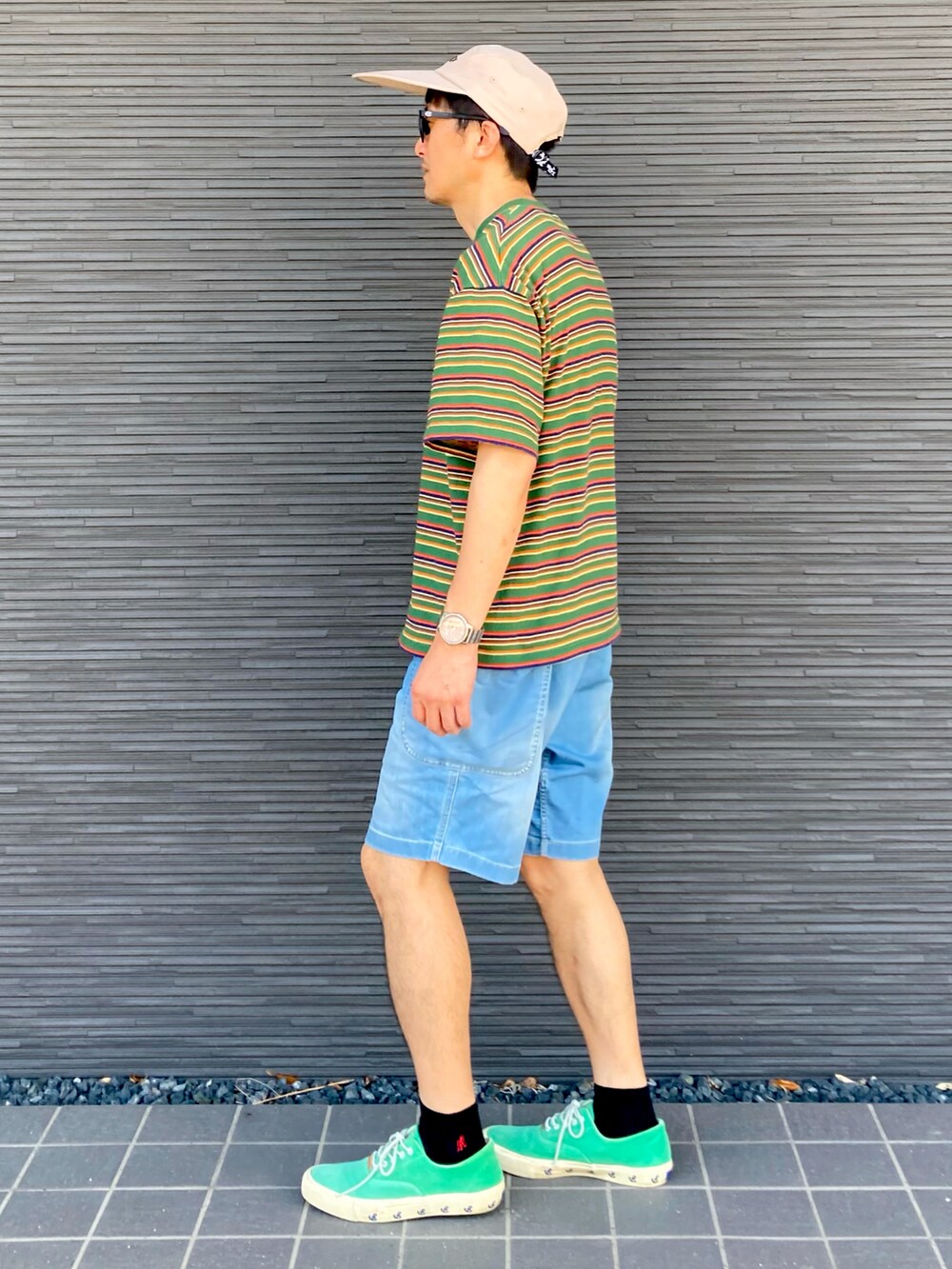 グリーン系のTシャツ/カットソー、ブルー系のデニムパンツ、グリーン系のスニーカーを着用したメンズの夏コーディネートの4枚目の写真
