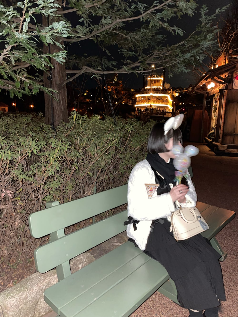 ホワイト系のスカート、ブラック系のローファー、ホワイト系のショルダーバッグを着用したレディースの冬コーディネートの2枚目の写真