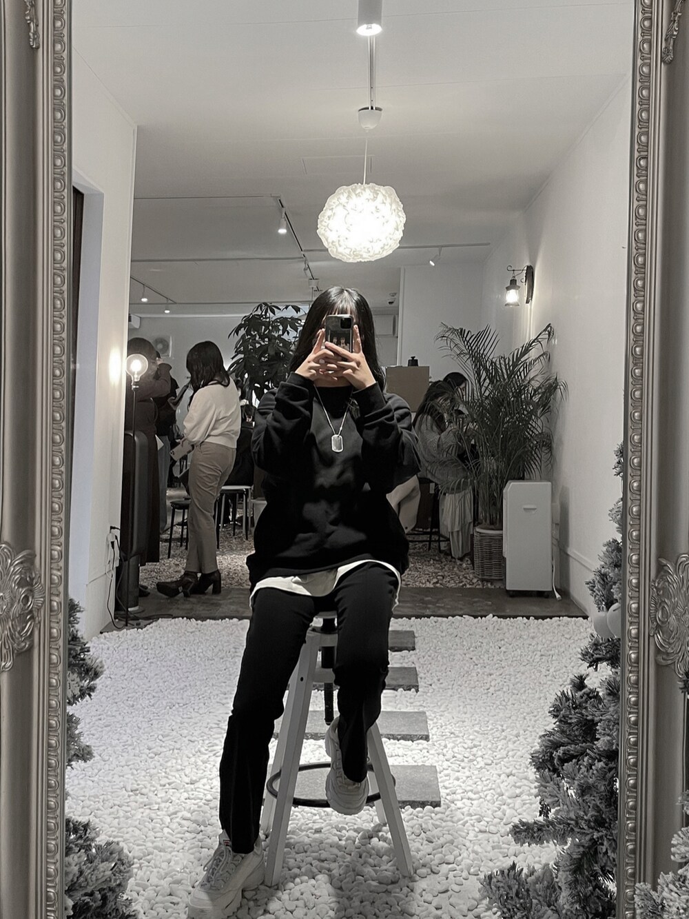 ブラック系のスラックス、ホワイト系のスニーカー、ブラック系のスウェットを着用したレディースの冬コーディネートの2枚目の写真