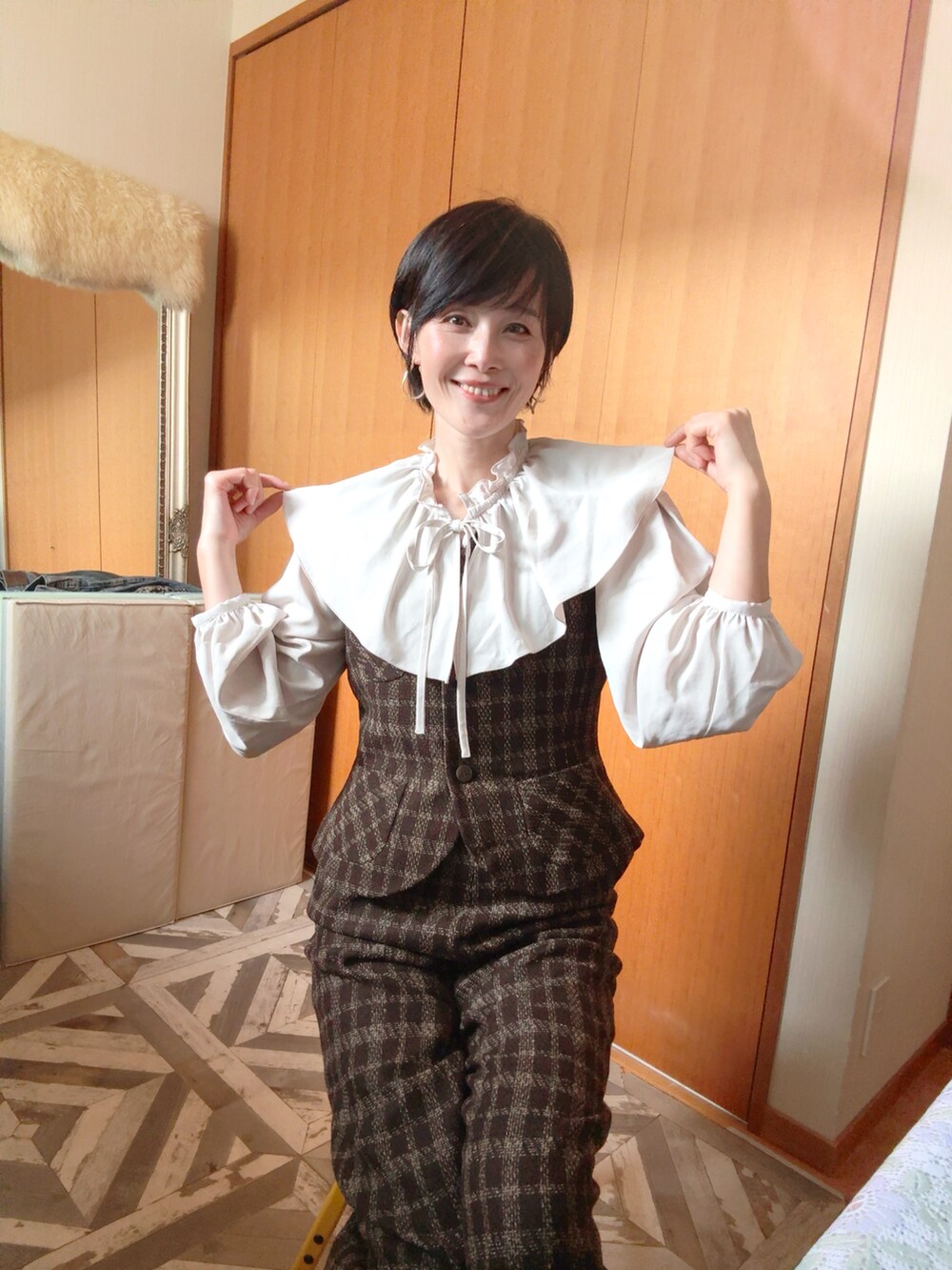 ブラウン系のダウンジャケット/コート、ブラウン系のベスト、ブラウン系のパンツを着用したレディースの冬コーディネートの3枚目の写真