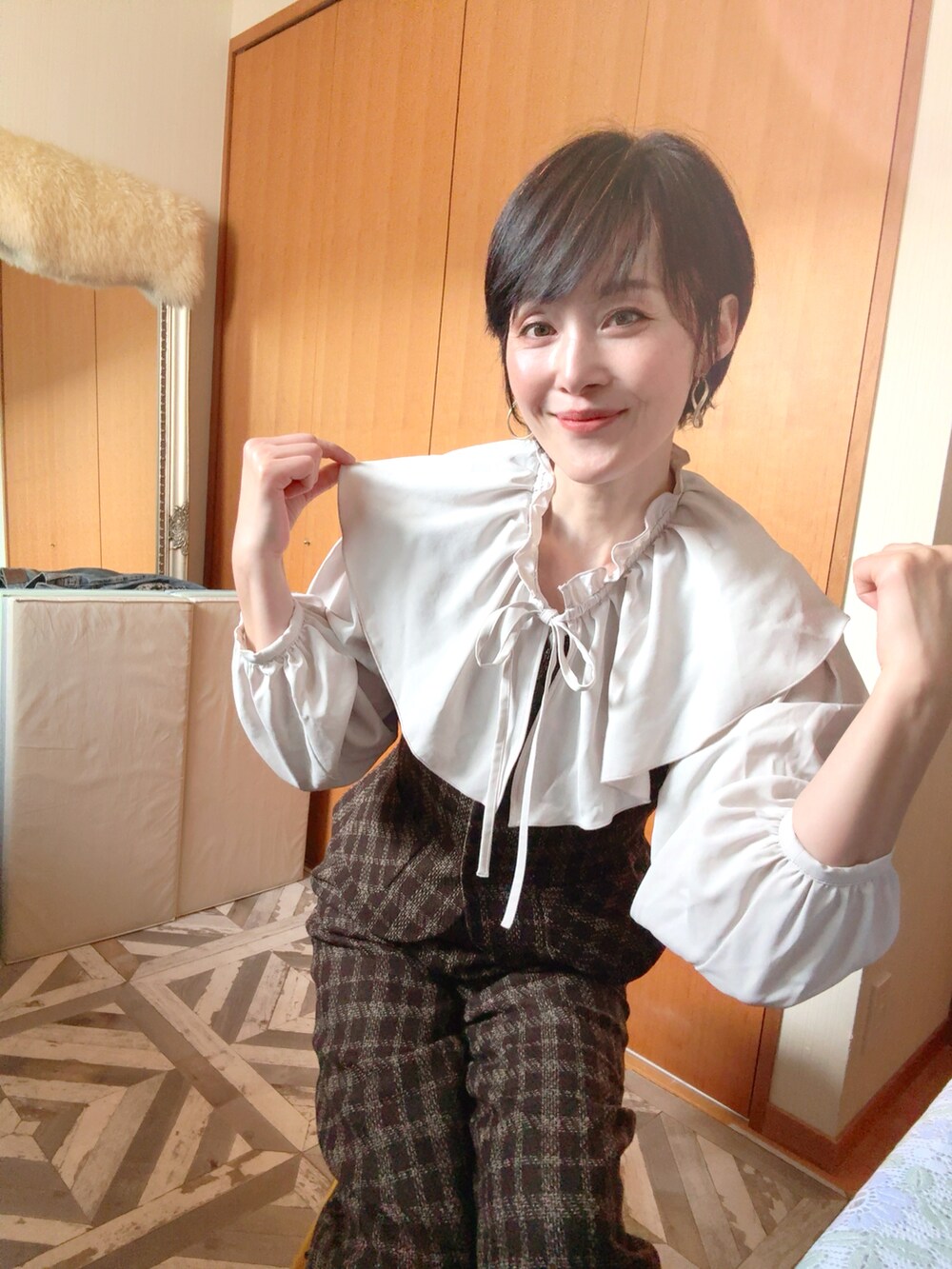 ブラウン系のダウンジャケット/コート、ブラウン系のベスト、ブラウン系のパンツを着用したレディースの冬コーディネートの4枚目の写真