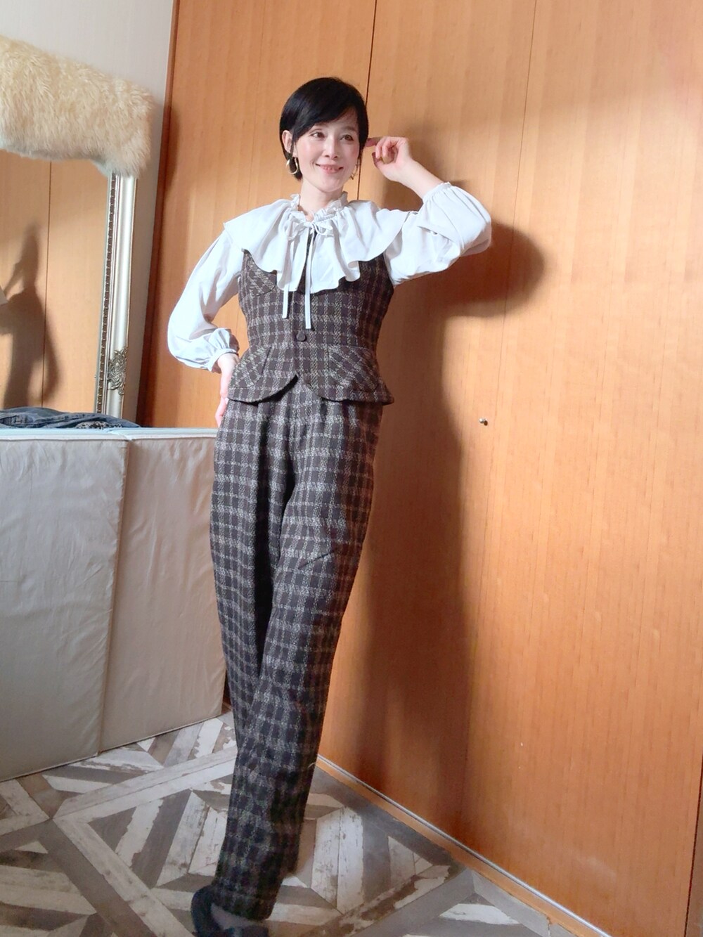 ブラウン系のダウンジャケット/コート、ブラウン系のベスト、ブラウン系のパンツを着用したレディースの冬コーディネートの2枚目の写真