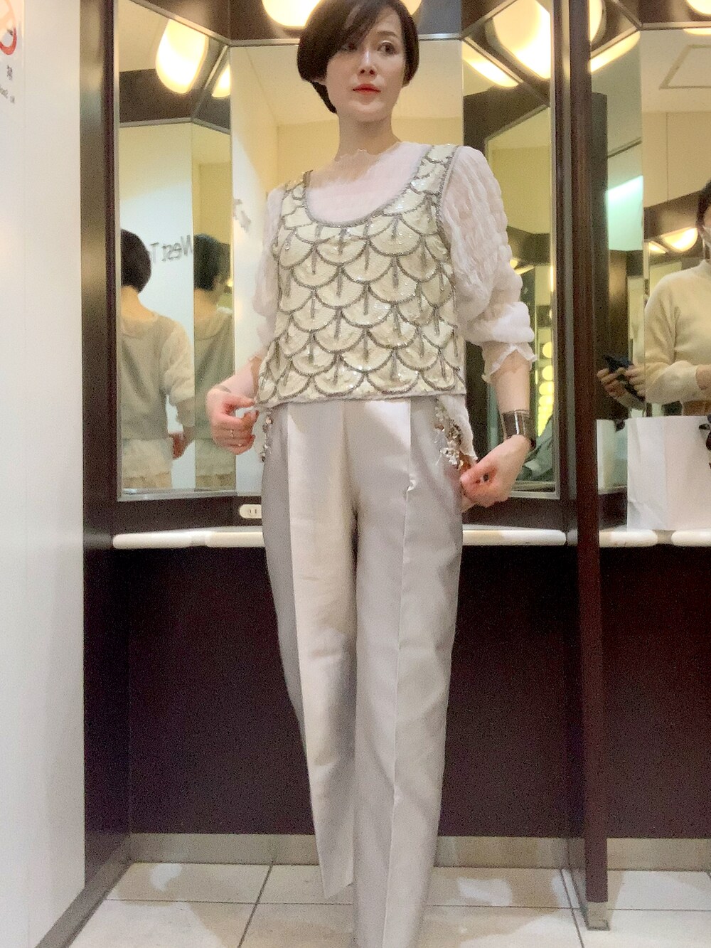 ホワイト系のTシャツ/カットソー、グレー系のタンクトップ、シルバー系のパンツを着用したレディースの春コーディネートの2枚目の写真