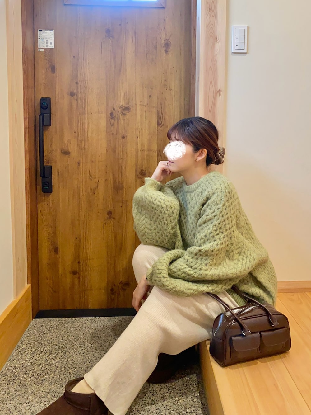 グリーン系のニット/セーター、ブラウン系のショルダーバッグ、ブラウン系のブーツを着用したレディースの冬コーディネートの3枚目の写真