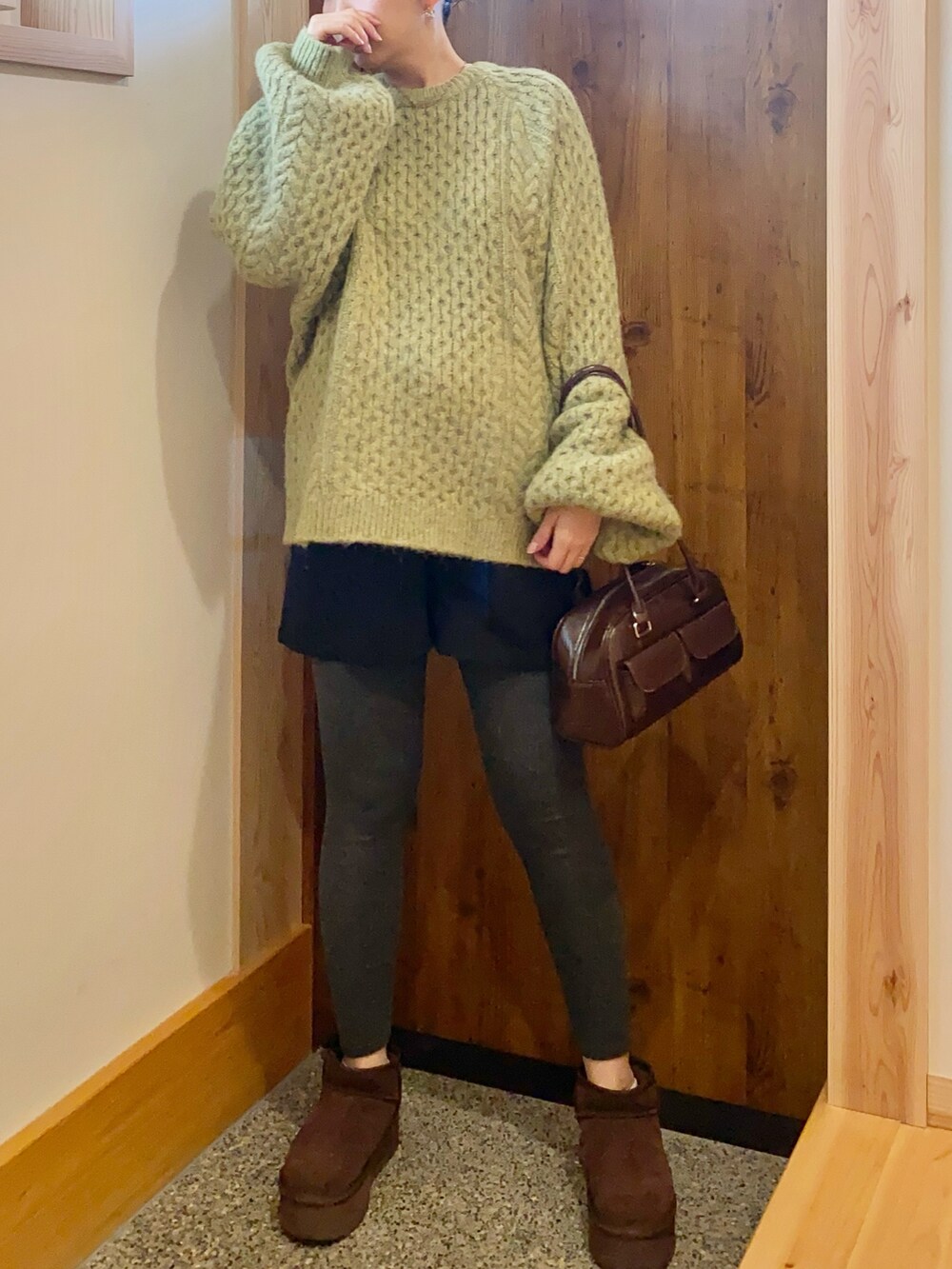 グリーン系のニット/セーターを着用したレディースの春コーディネートの2枚目の写真