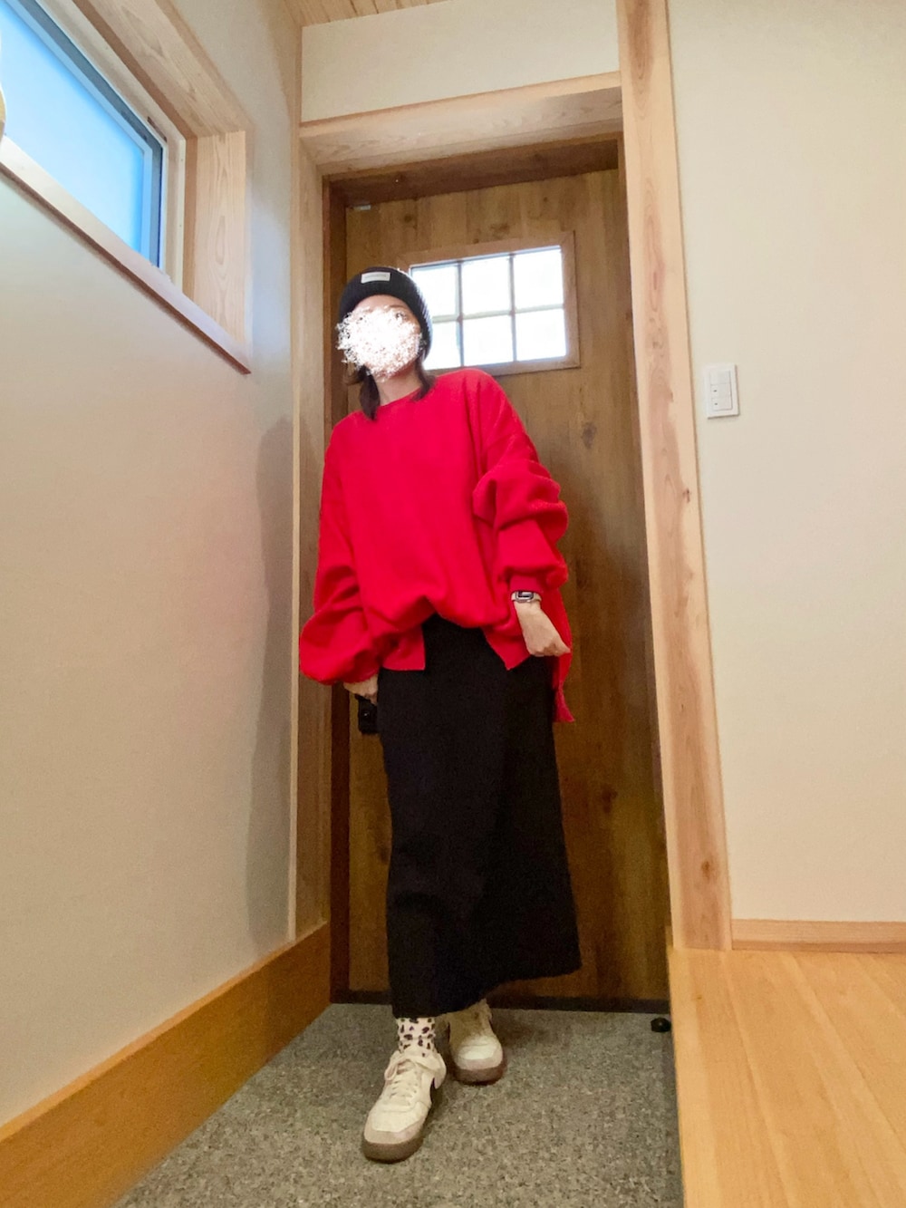 レッド系のスウェット、ブラック系のスカートを着用したレディースの冬コーディネートの2枚目の写真