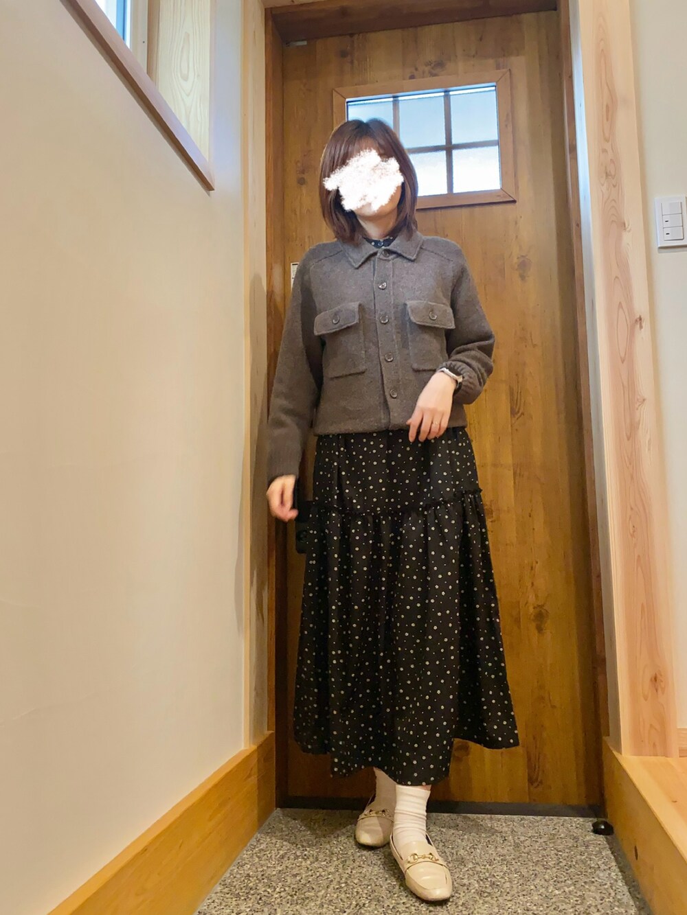 ブラウン系のカーディガン/ボレロ、ブラック系のワンピースを着用したレディースの秋コーディネートの2枚目の写真
