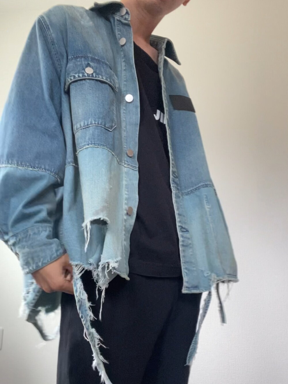 ブルー系のデニムジャケット、ブラック系のTシャツ/カットソー、ブラック系のスラックスを着用したメンズの秋コーディネートの2枚目の写真