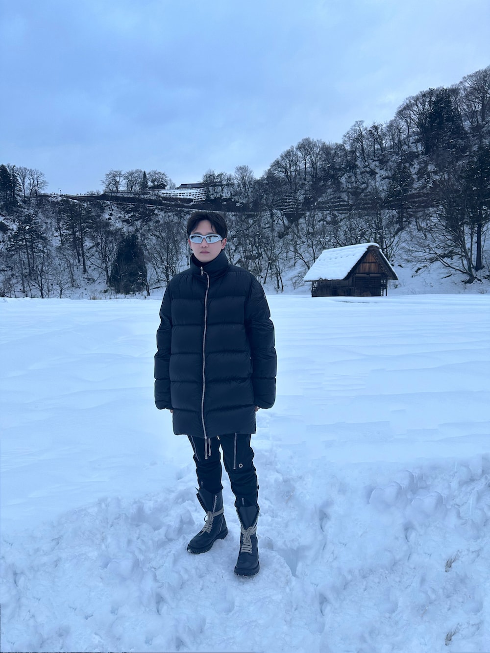 ブラック系のダウンジャケット/コート、ブラック系のその他パンツ、ブラック系のブーツを着用したメンズの冬コーディネートの2枚目の写真