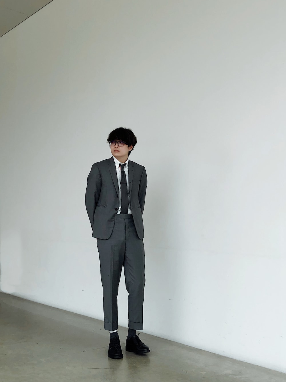 グレー系のスーツセット、ブラック系のローファー、グレー系のネクタイを着用したメンズの夏コーディネートの3枚目の写真