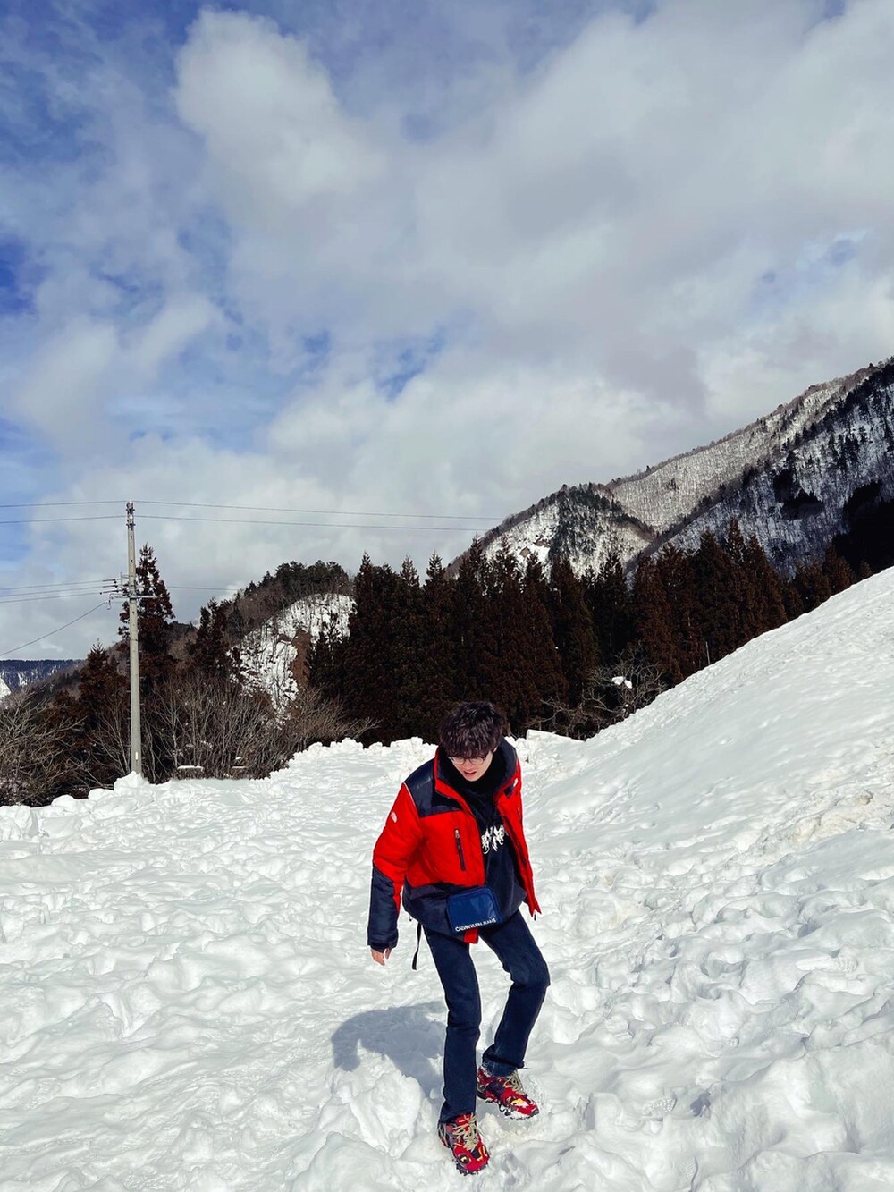 ブラック系のパーカー、ブラック系のパンツ、ホワイト系のスニーカーを着用したメンズの秋コーディネートの2枚目の写真