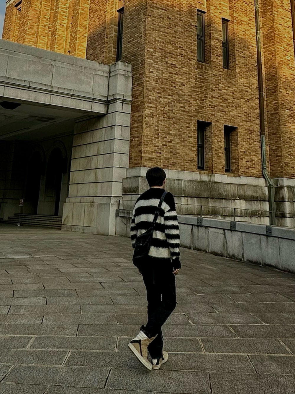 ブラック系のその他パンツ、ブラック系のニット/セーター、ベージュ系のシューズを着用したメンズの冬コーディネートの3枚目の写真