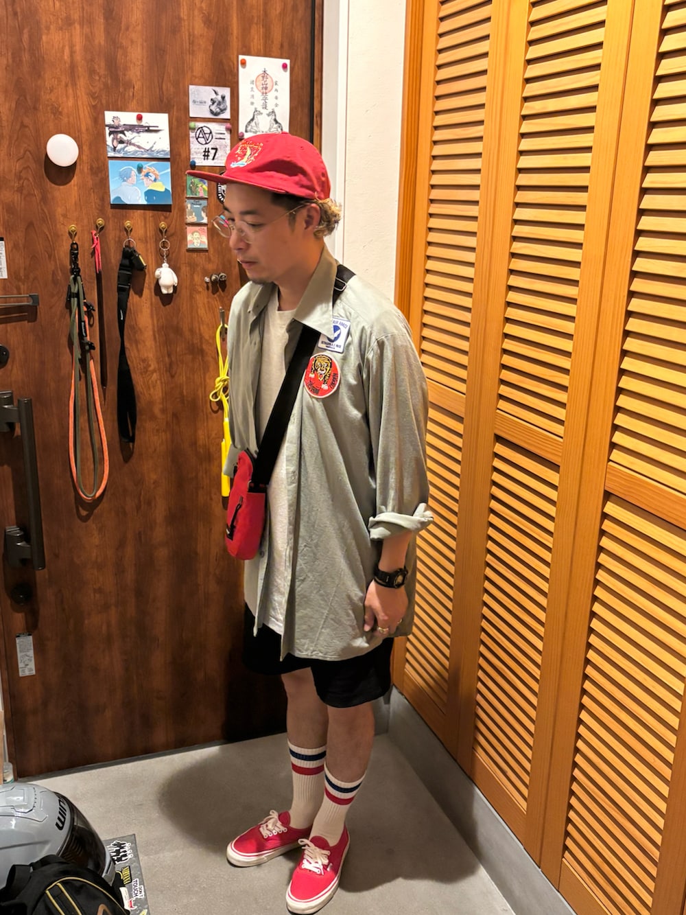 レッド系のスニーカー、レッド系のショルダーバッグ、ブラック系のデジタル腕時計を着用したメンズの春コーディネートの2枚目の写真