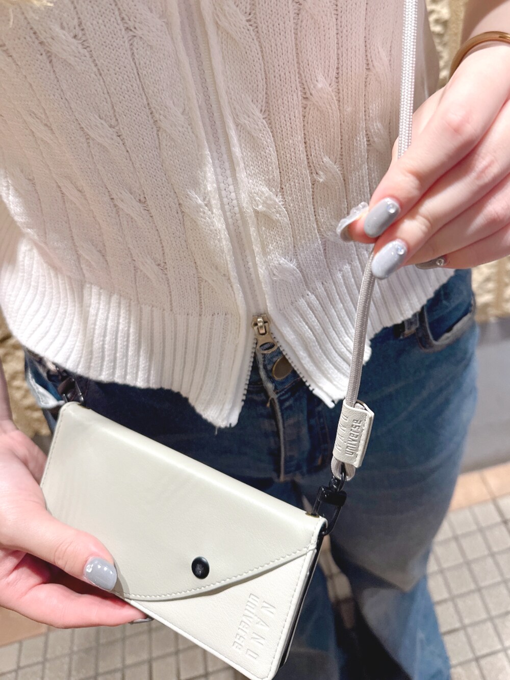 グレー系のスマホグッズ、グレー系のスマホケース/カバーを着用したレディースの夏コーディネートの2枚目の写真