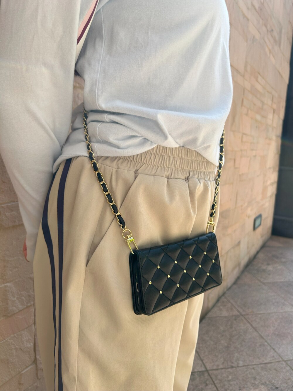 ブラック系のスマホグッズ、ブラック系のスマホケース/カバーを着用したレディースの春コーディネートの3枚目の写真