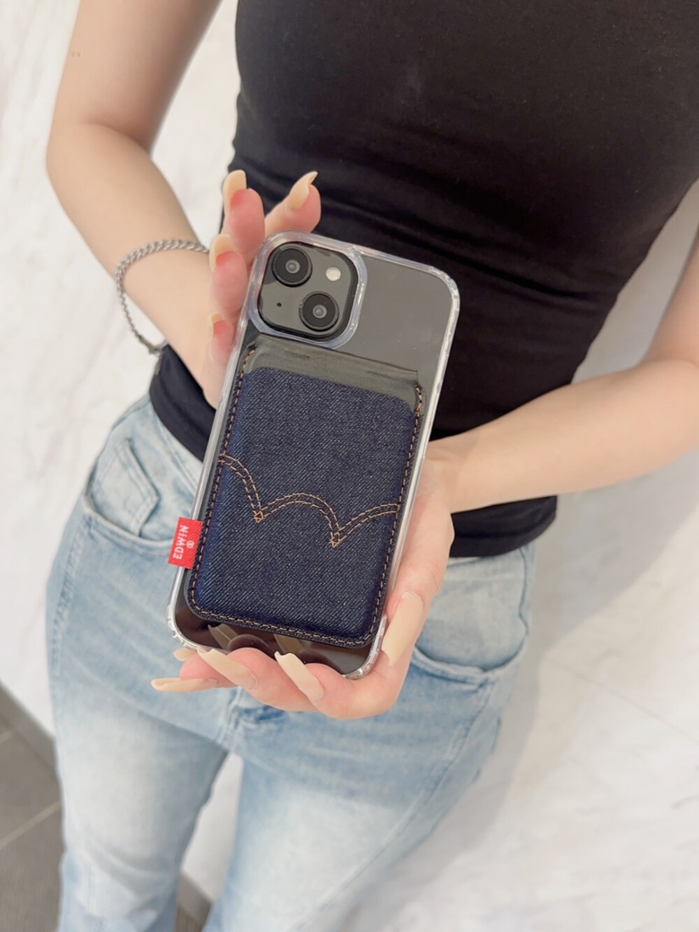 ブルー系のスマホグッズを着用したレディースの夏コーディネートの2枚目の写真