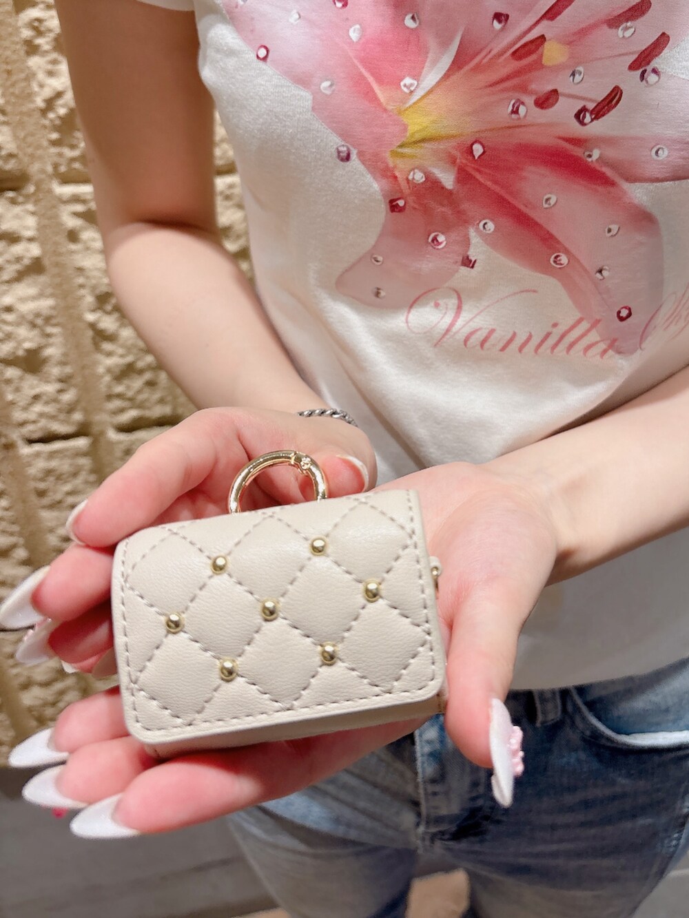 ベージュ系のヘッドフォン/イヤホンを着用したレディースの夏コーディネートの2枚目の写真