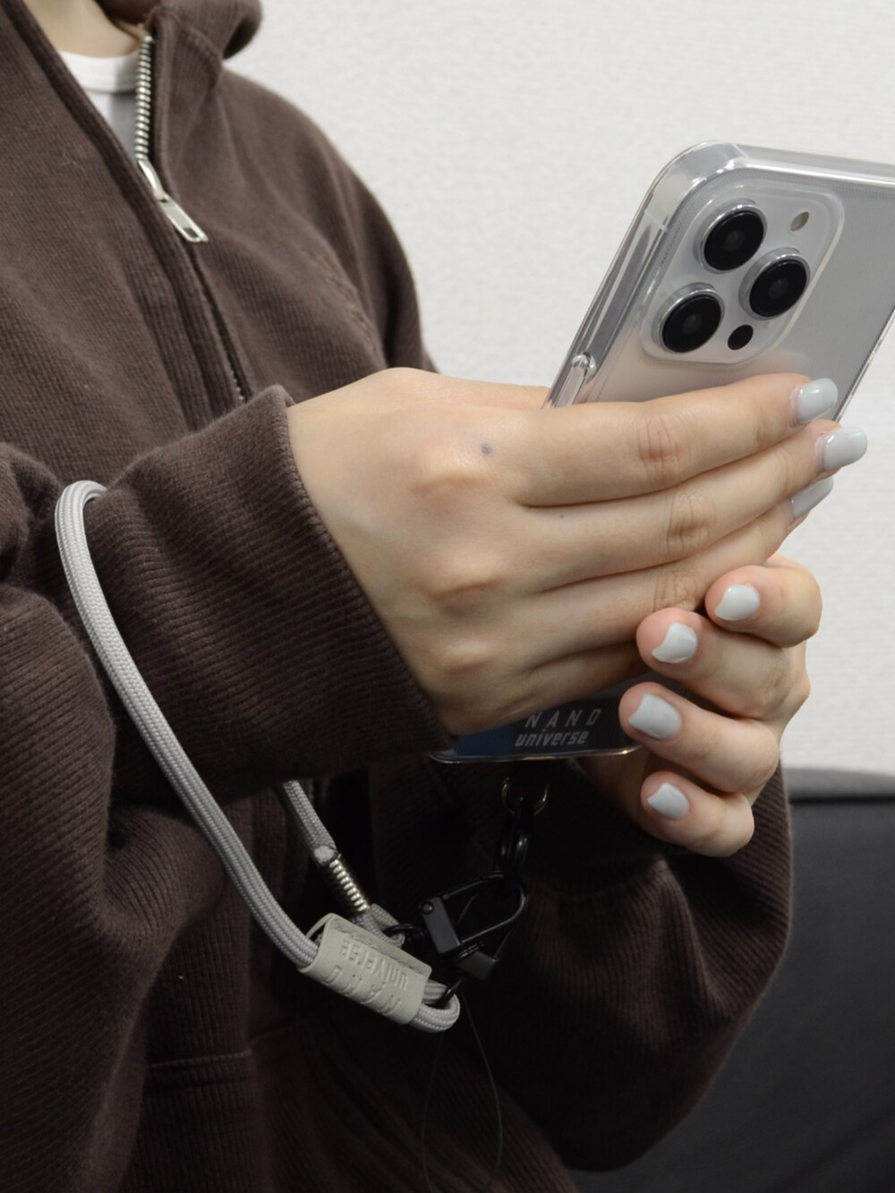 グレー系のスマホグッズを着用したレディースの夏コーディネートの2枚目の写真