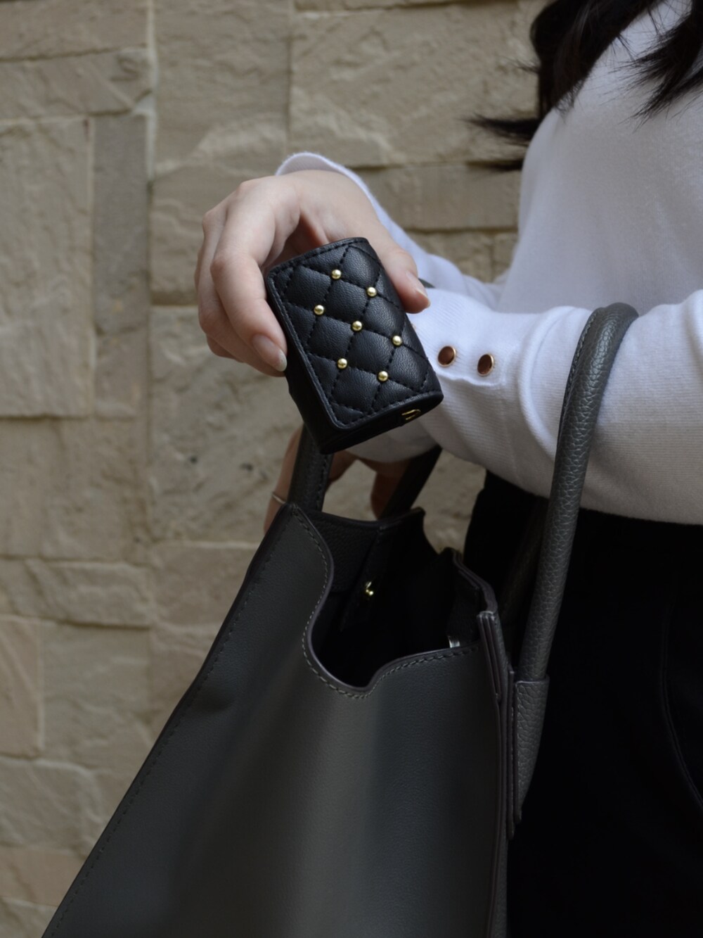 ブラック系のヘッドフォン/イヤホン、ブラック系のスマホグッズを着用したレディースの春コーディネートの3枚目の写真