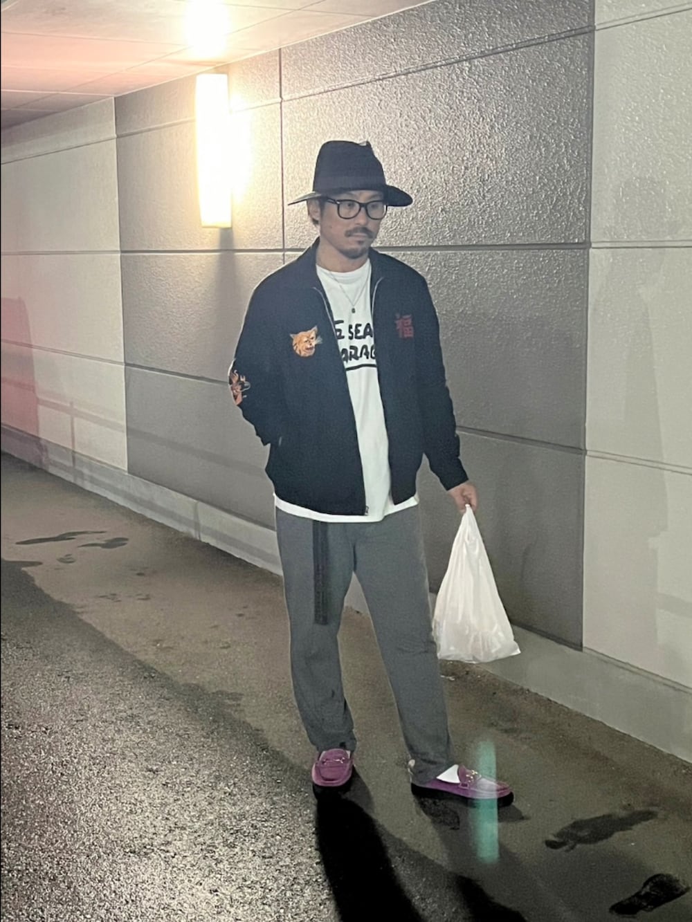 ブラック系のスカジャン、ホワイト系のTシャツ/カットソー、グレー系のスラックスを着用したメンズの春コーディネートの2枚目の写真