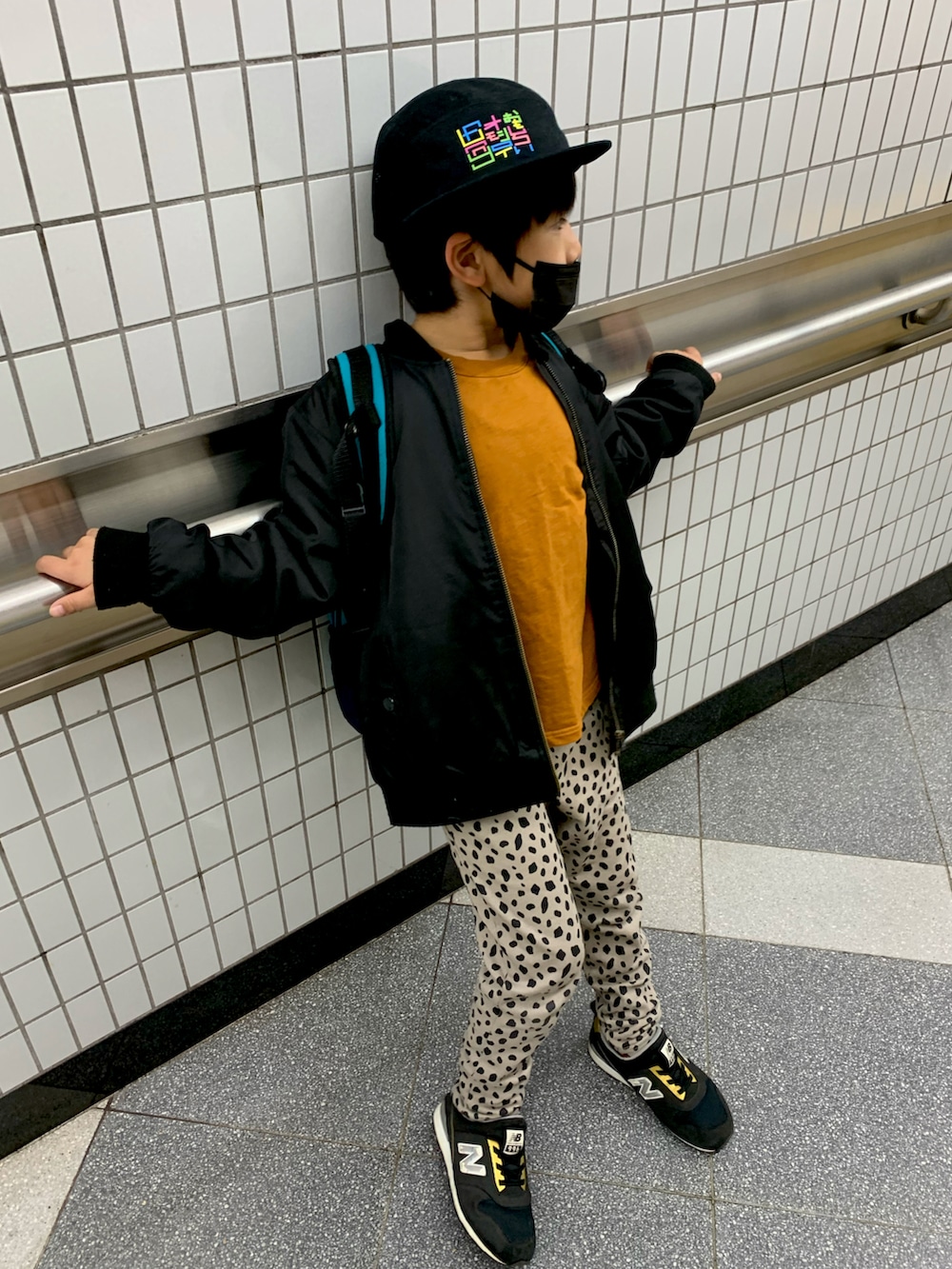 イエロー系のTシャツ/カットソー、ブラック系のMA-1、グレー系のその他パンツを着用したキッズの冬コーディネートの2枚目の写真