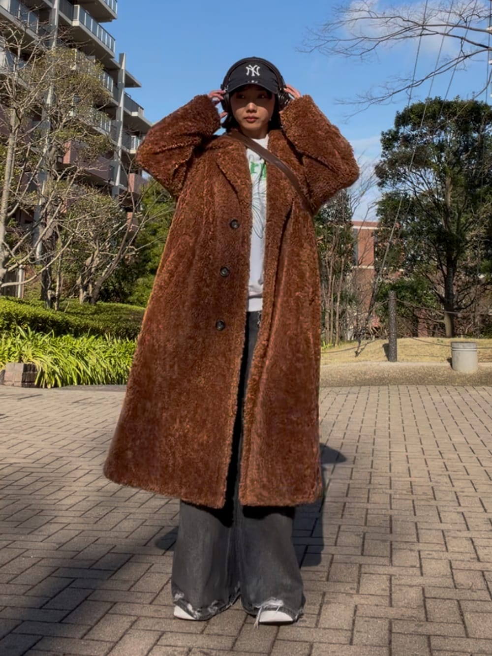 ブラック系のデニムパンツ、グレー系のスウェット、ホワイト系のスニーカーを着用したレディースの春コーディネートの3枚目の写真