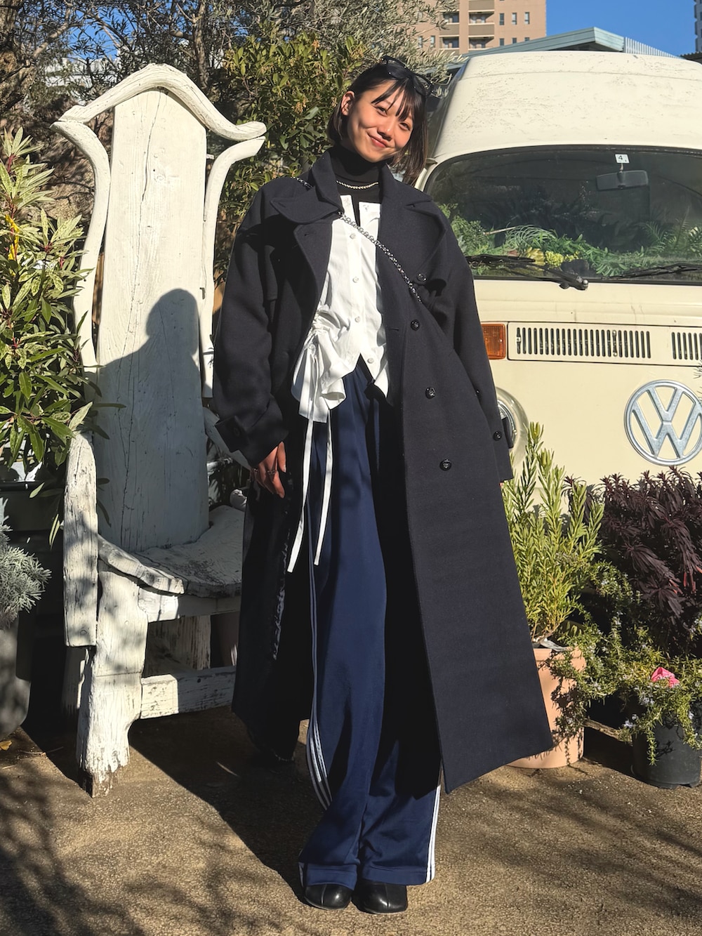 ブラック系のその他パンツ、ホワイト系のキャミソール、ブルー系のステンカラーコートを着用したレディースの冬コーディネートの2枚目の写真