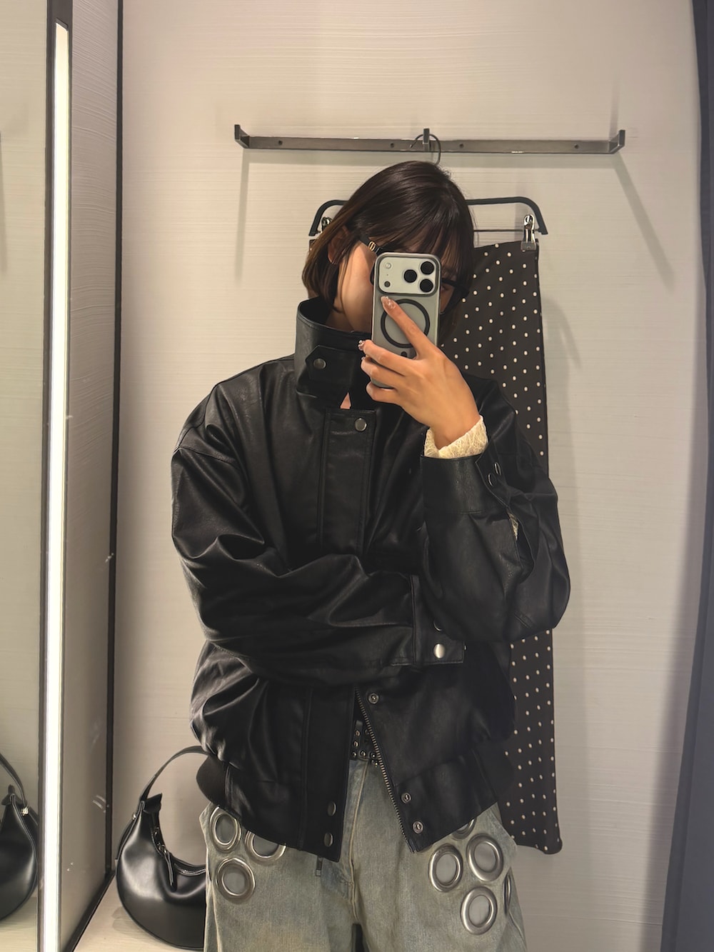 ホワイト系のシャツ/ブラウス、ブラック系のブルゾン、ブルー系のデニムパンツを着用したレディースの秋コーディネートの3枚目の写真