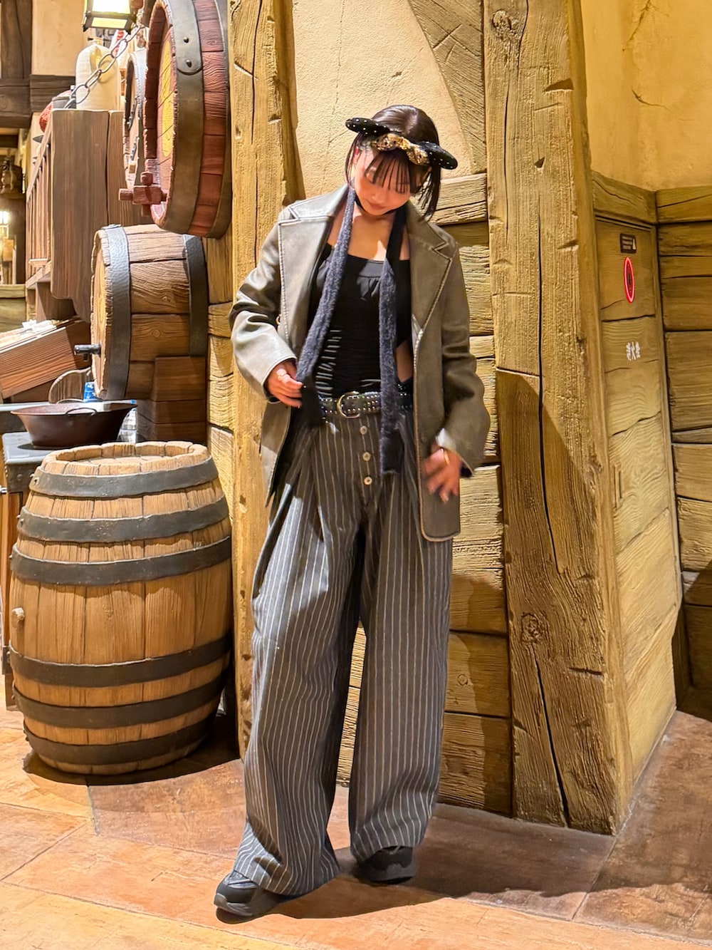 グレー系のスラックス、ブラック系のスニーカー、その他のテーラードジャケットを着用したレディースの秋コーディネートの2枚目の写真