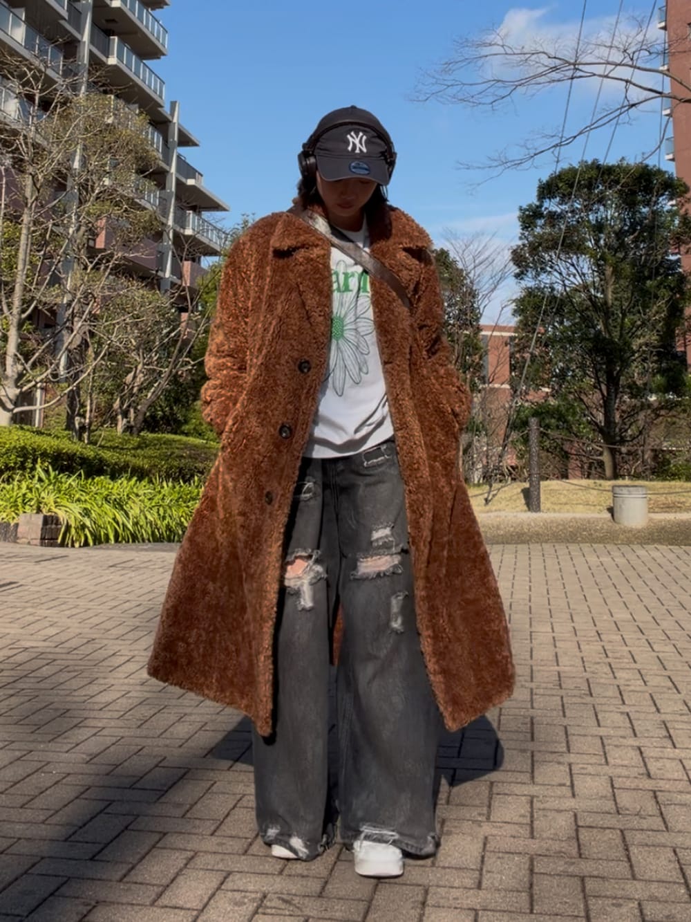 ブラック系のデニムパンツ、グレー系のスウェット、ホワイト系のスニーカーを着用したレディースの春コーディネートの2枚目の写真