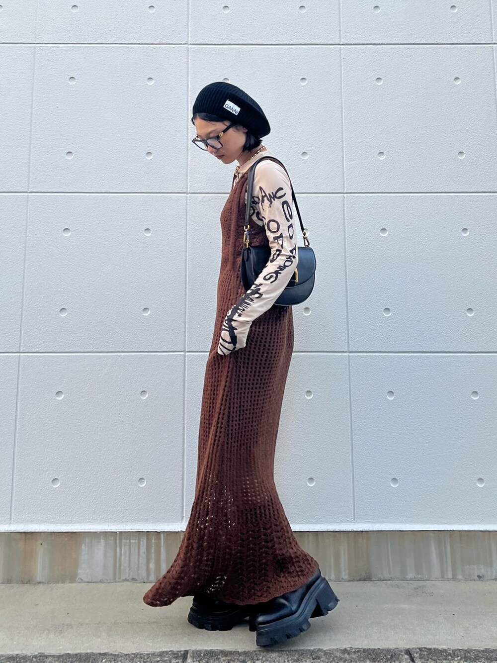 ベージュ系のTシャツ/カットソー、ブラック系のショルダーバッグ、ブラック系のブーツを着用したレディースの秋コーディネートの2枚目の写真