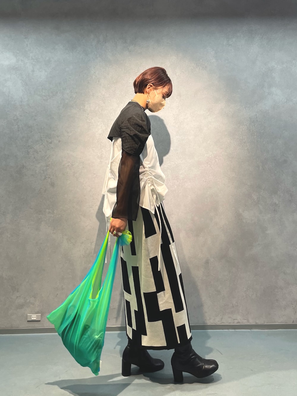 ブラック系のスカート、ホワイト系のキャミソール、ブラック系のTシャツ/カットソーを着用したレディースの春コーディネートの2枚目の写真