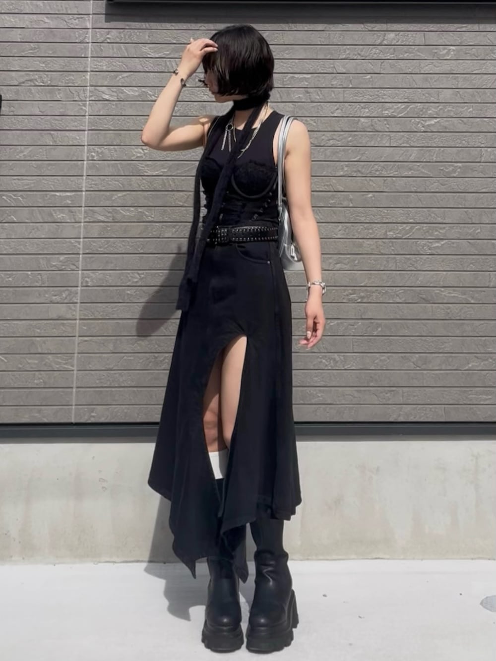 ブラック系のブーツ、ブラック系のデニムスカート、ブラック系のベルトを着用したレディースの夏コーディネートの3枚目の写真