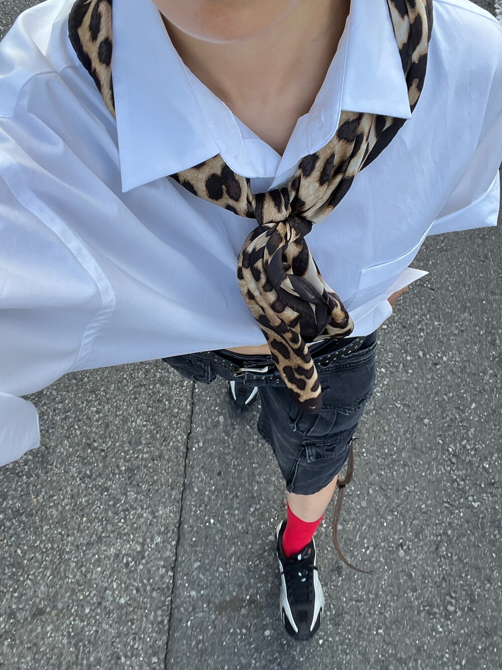 ブラック系のデニムパンツ、シルバー系のスニーカー、ブラウン系のショルダーバッグを着用したレディースの秋コーディネートの3枚目の写真