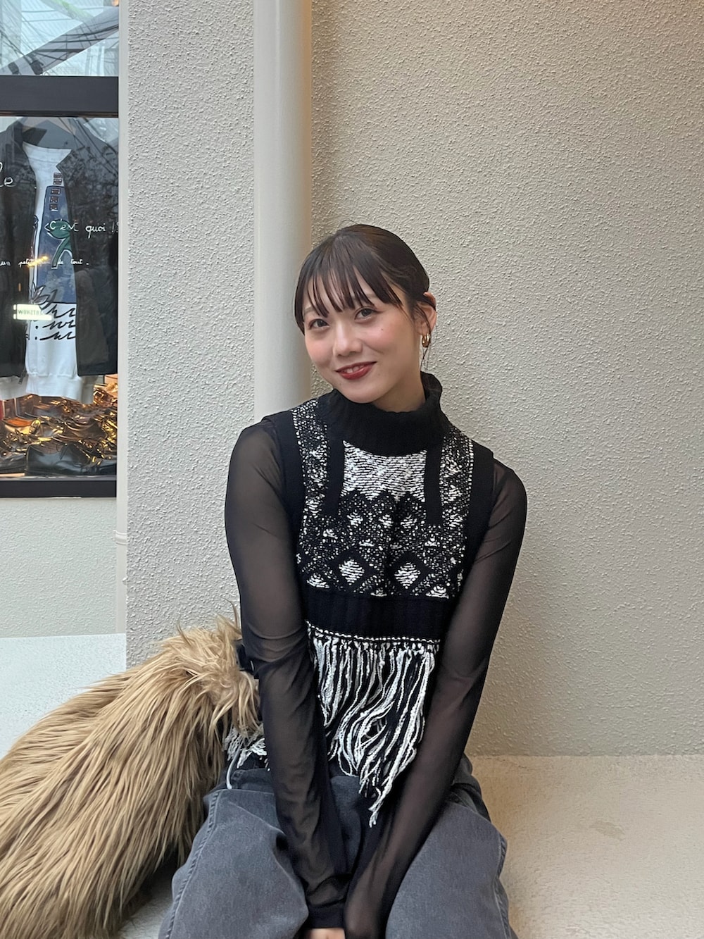 ブラック系のデニムパンツ、ブラック系のニット/セーター、ホワイト系のその他アウターを着用したレディースの秋コーディネートの2枚目の写真