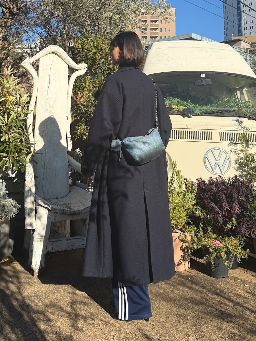 ブラック系のその他パンツ、ホワイト系のキャミソール、ブルー系のステンカラーコートを着用したレディースの冬コーディネートの3枚目の写真