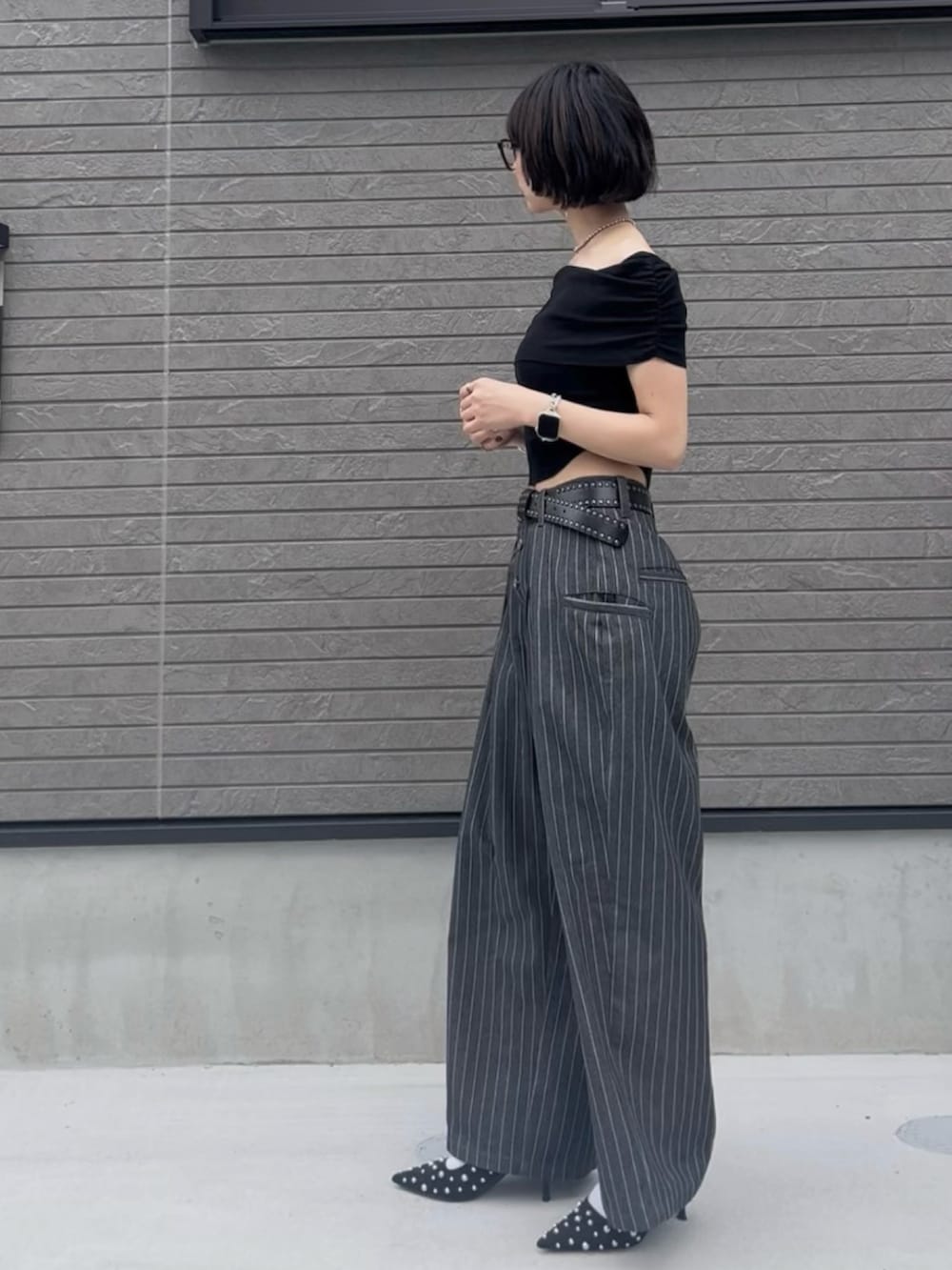 ブラック系のシャツ/ブラウス、グレー系のスラックス、ブラック系のパンプスを着用したレディースの夏コーディネートの2枚目の写真