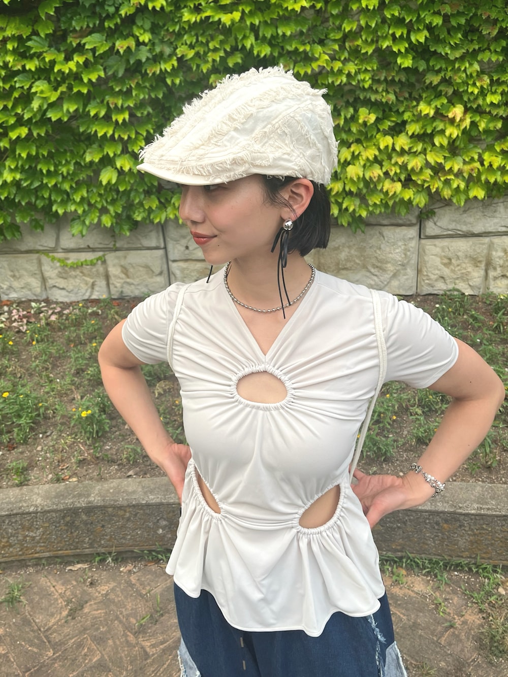 ホワイト系のTシャツ/カットソー、ブラック系のスニーカー、ブルー系のデニムパンツを着用したレディースの夏コーディネートの4枚目の写真