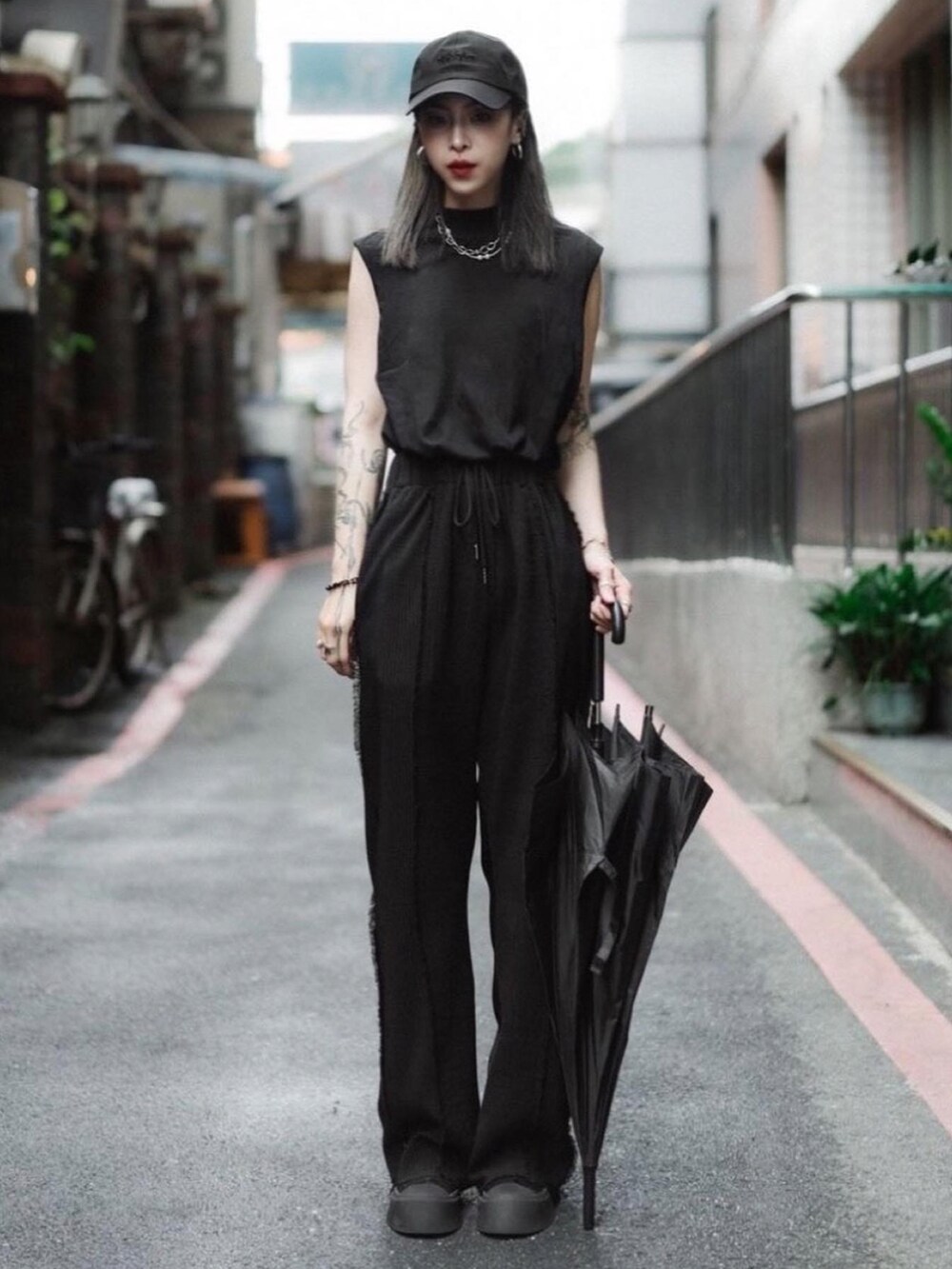 ブラック系のパンツ、ブラック系のその他トップス、ブラック系のキャップを着用したレディースの春コーディネートの5枚目の写真