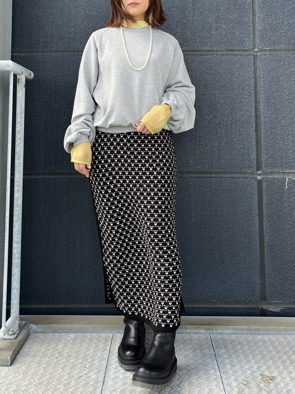 ブラック系のスカート、グレー系のスウェット、イエロー系のTシャツ/カットソーを着用したレディースの秋コーディネートの3枚目の写真