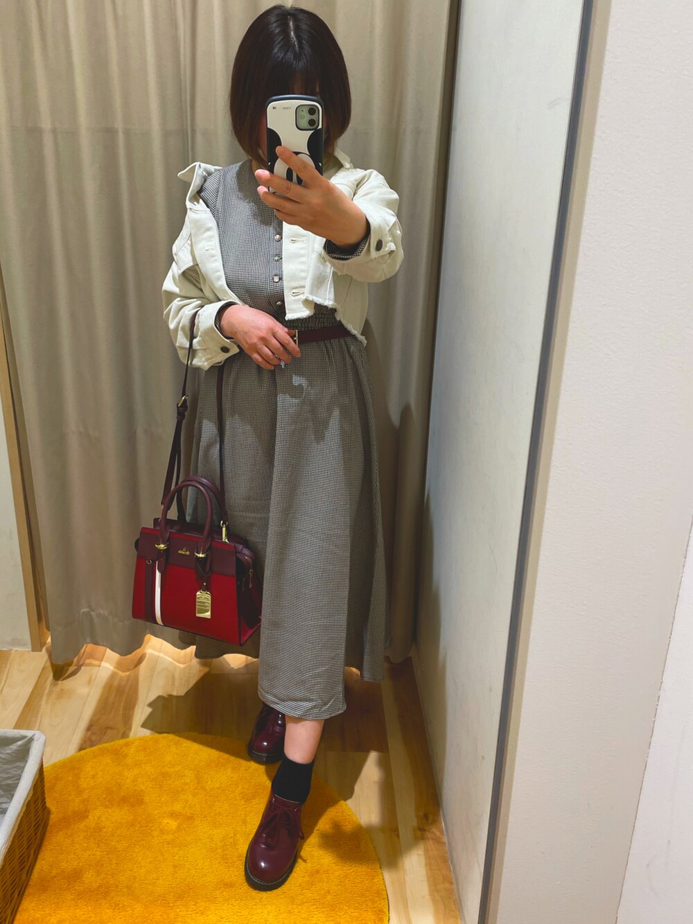 ホワイト系のデニムジャケット、レッド系のドレスシューズ、レッド系のハンドバッグを着用したレディースの冬コーディネートの2枚目の写真