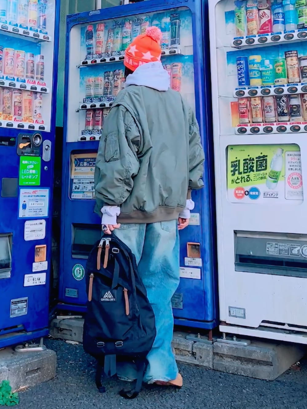 グレー系のパーカー、ブラック系のバックパック/リュック、グリーン系のMA-1を着用したレディースの冬コーディネートの4枚目の写真