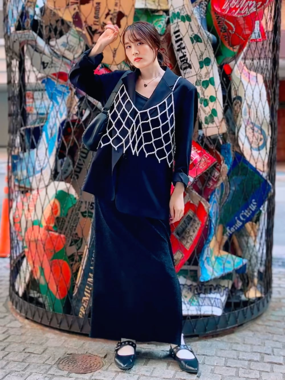 ブラック系のノーカラージャケット、ブラック系のスカート、ホワイト系のベストを着用したレディースの秋コーディネートの4枚目の写真