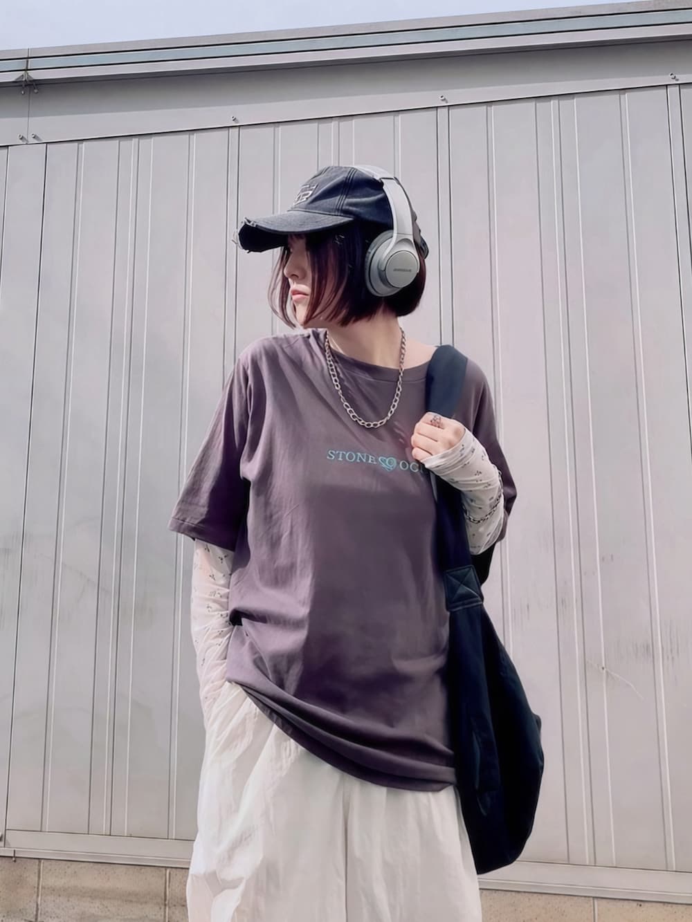 ブラック系のショルダーバッグ、ホワイト系のTシャツ/カットソー、ブラック系のスリッポンを着用したレディースの夏コーディネートの3枚目の写真