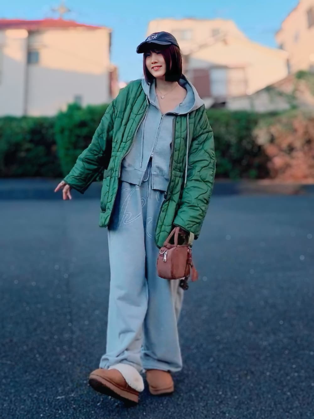 グレー系のパーカー、グレー系のスウェットパンツ、ブラウン系のボストンバッグを着用したレディースの冬コーディネートの2枚目の写真