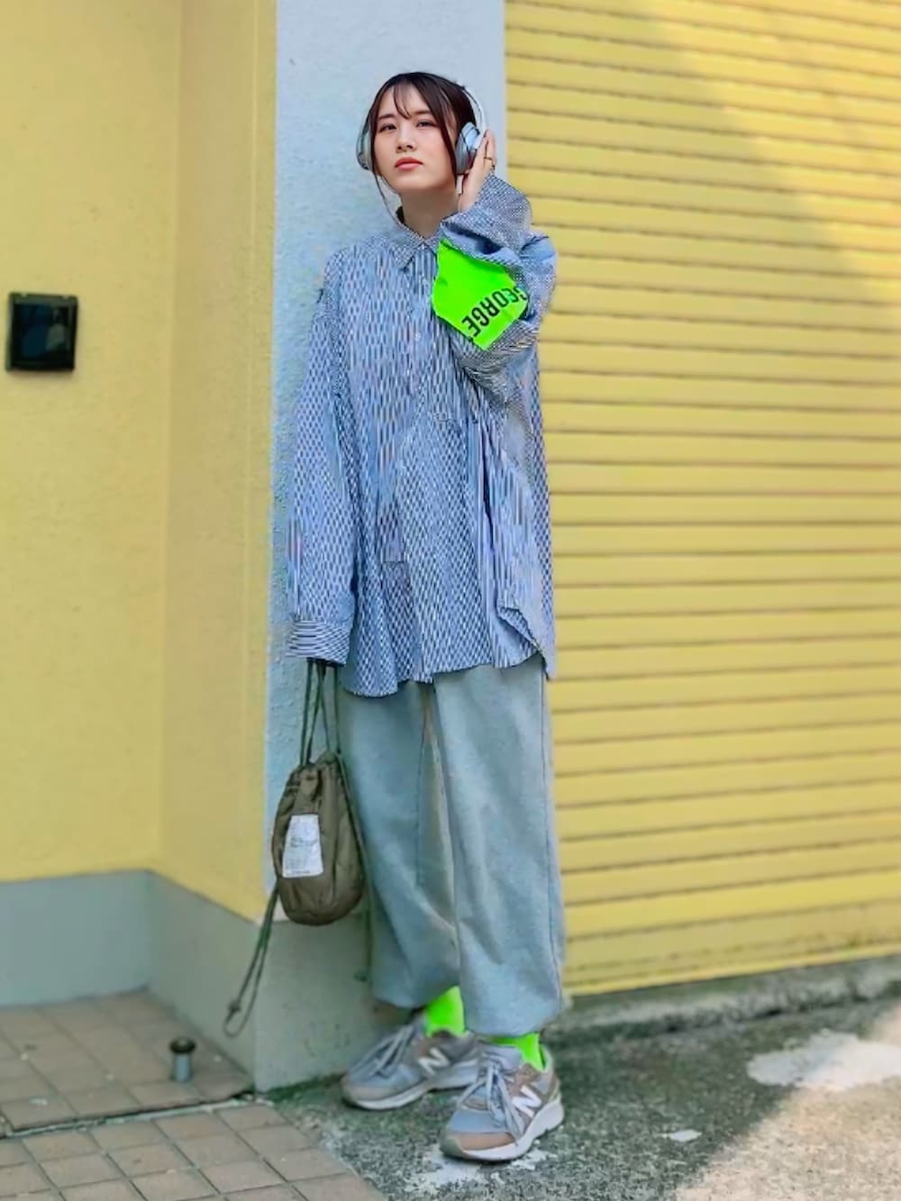 グレー系のスウェットパンツ、グリーン系のショルダーバッグ、グレー系のスニーカーを着用したレディースの春コーディネートの4枚目の写真