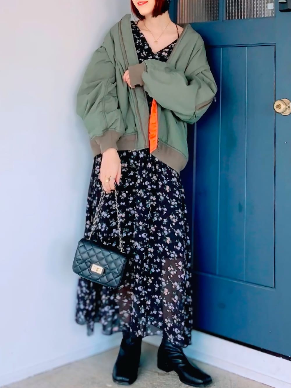 ブラック系のショルダーバッグ、ブラック系のワンピース/ドレス、ブラック系のブーツを着用したレディースの冬コーディネートの2枚目の写真