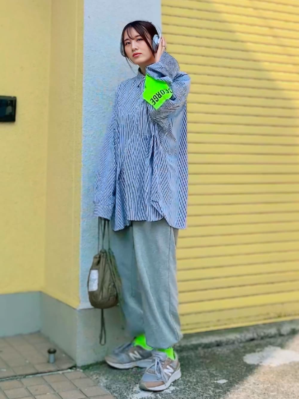 グレー系のスウェットパンツ、グリーン系のショルダーバッグ、グレー系のスニーカーを着用したレディースの春コーディネートの2枚目の写真