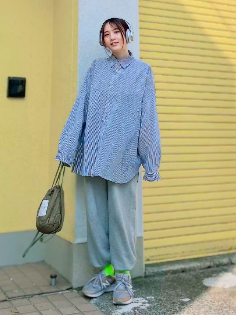 グレー系のスウェットパンツ、グリーン系のショルダーバッグ、グレー系のスニーカーを着用したレディースの春コーディネートの3枚目の写真