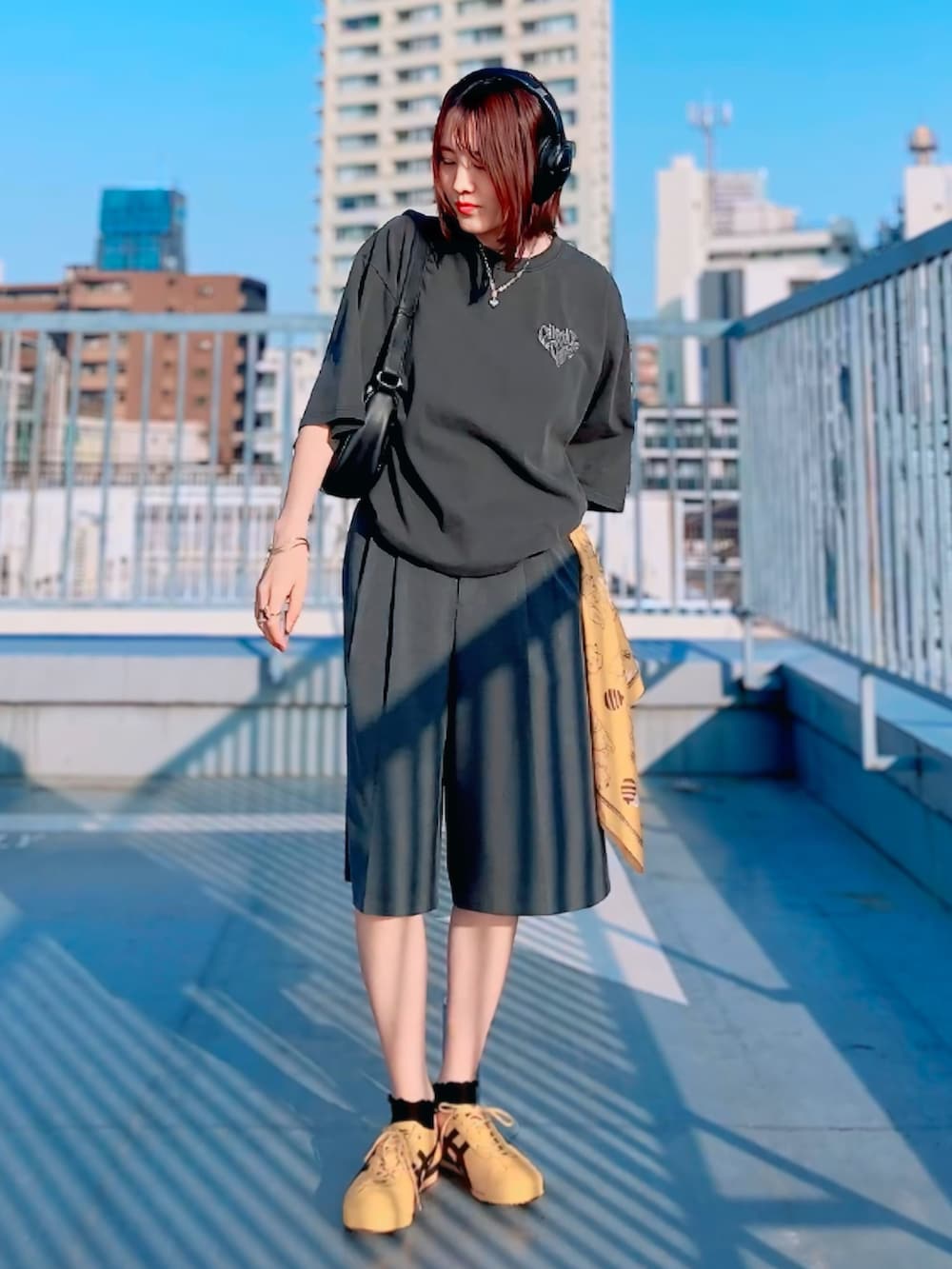 グレー系のTシャツ/カットソー、グレー系のその他パンツ、イエロー系のスニーカーを着用したレディースの春コーディネートの2枚目の写真